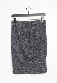 Jupe crayon en tricot gris foncé avec un tissu texturé, finition lisse, coupe mi-longue et taille dissimulée. Suspendue à un cintre noir.