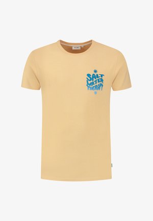 Majica s kratkimi rokavi in okroglim izrezom v svetlo rumeni barvi iz bombaža. Ima modro besedilo z napisom "SALT WATER THERAPY" in majhno zvezdico nad njim.
