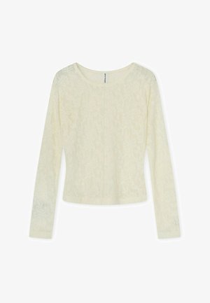 Hosszú ujjú, krémszínű, testhezálló felső finom virágos csipkemintával és kerek nyakkivágással, laposan fehér háttéren elhelyezve.