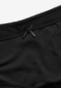 Culotte en tissu noir avec une délicate bordure en dentelle et un petit accent en satin sur la taille. Texture lisse avec un ajustement extensible.