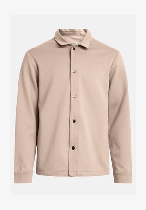 Beige Hemd mit Knöpfen, aus weichem Stoff gefertigt, mit umgeschlagenem Kragen, langen Ärmeln und fünf schwarzen Druckknöpfen an der Vorderseite.