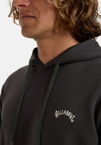 Dark gray hoodie made of cotton, featuring a front kangaroo pocket, adjustable drawstrings, and the embroidered word "BILLABONG" in white.