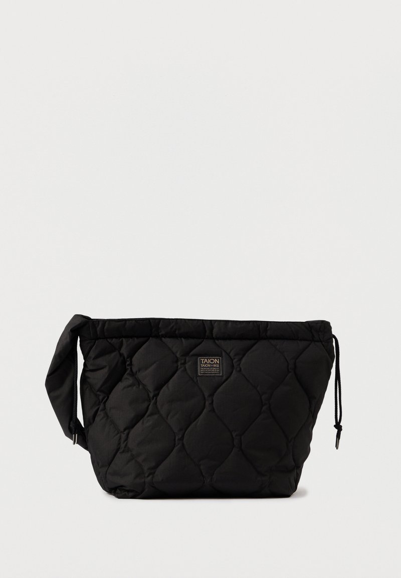 Μαύρη τσάντα με καπιτονέ σχέδιο, ορθογώνιας μορφής, με κλείσιμο κορδονιού, φαρδύ λουρί και λάβαρο στην μπροστινή πλευρά. Λείος υφής.