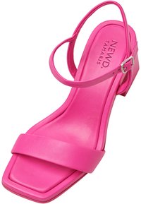Sandalin in pelle rosa con punta quadrata, una fascia larga sul davanti e sottili cinturini alla caviglia. Presenta un piccolo tacco a blocco.