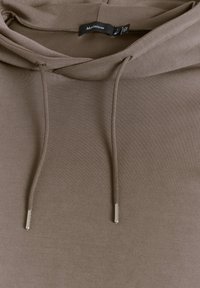 Sudadera con capucha marrón, que cuenta con un cordón con puntas metálicas, hecha de una tela suave y con un diseño sencillo y limpio.