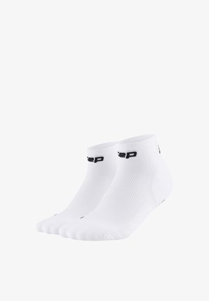 Pair of white ankle socks with black logo text on the cuff, ribbed texture, and seamless toe design.