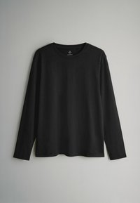 Juodas ilgomis rankovėmis marškinėliai, pagaminti iš minkštos medvilnės, su apvaliu kaklu, laisvu pjaustymu ir minimalizmu be raštų ar akcentų.