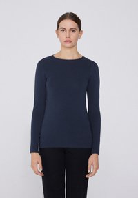 Top de manga larga en color navy de tejido liso con cuello redondo. Silueta ajustada, diseño minimalista sin patrones o acentos visibles.