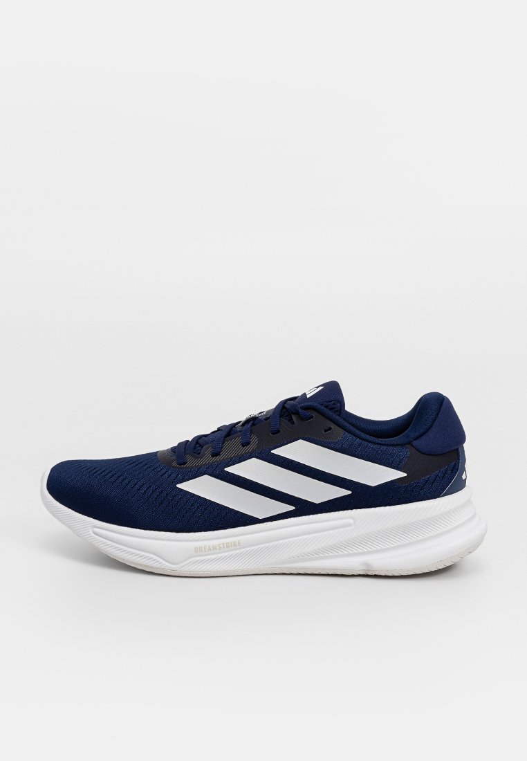Zapatilla atlética de color navy con parte superior de malla transpirable, diseño de tres rayas blancas y una suela blanca acolchada con textura para mayor agarre.