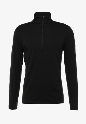 Czarna polo z długim rękawem, z wysokim kołnierzem i pół-zamkiem z przodu. Wykonana z gładkiego, teksturowanego materiału. Prosty fason bez wzorów i akcentów.