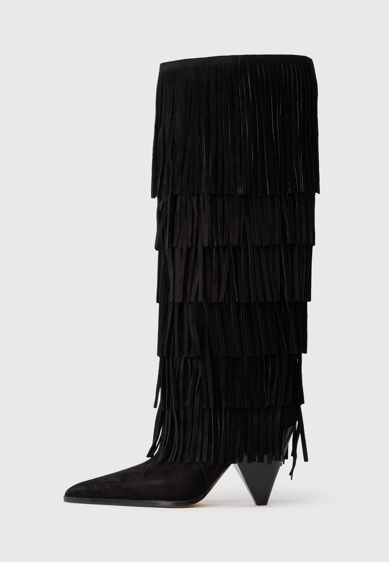 Fekete velúr, térdhéig érő csizma, réteges bojtokkal és hegyes orral, különleges, szögletes sarokkal, fehér háttér előtt bemutatva.