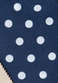 Tessuto blu navy con una trama a maglia testurizzata, caratterizzato da pois bianchi lucidi disposti uniformemente. I bordi hanno un dettaglio in pizzo nero a scallop.