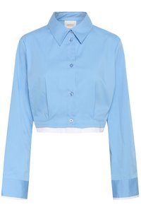 Κοντοκομμένο ανοιχτό γαλάζιο πουκάμισο με μακριά μανίκια, μυτερό γιακά και λευκή επένδυση στο τελείωμα και τα μανίκια.