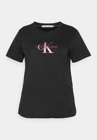 Černé bavlněné tričko s krátkým rukávem, kulatým výstřihem a růžovým logem, které hlásí "CALVIN KLEIN JEANS" na přední straně.