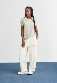 New Balance LINEAR HERITAGE RINGER - T-shirts med print - green