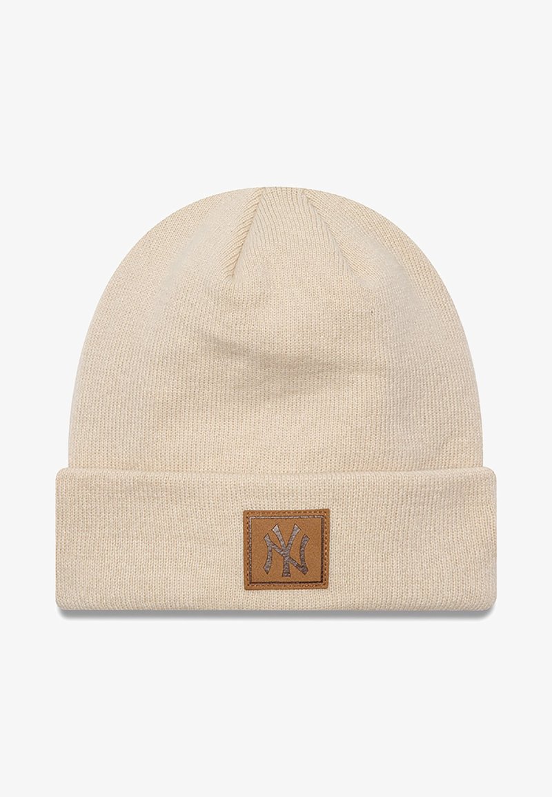 Bonnet en tricot crème avec une bordure repliée, doté d'un patch en cuir carré avec un logo en relief. Texture douce et design simple pour un maximum de chaleur.