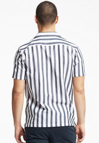 Camicetta a maniche corte con righe verticali navy e bianche, realizzata in tessuto leggero, con orlo dritto e colletto casual.