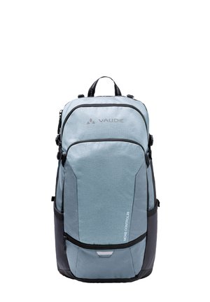 Zaino di colore blu chiaro con accenti scuri, caratterizzato da tessuto testurizzato, diverse tasche con zip e spallacci regolabili per il comfort.