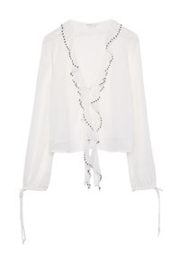 Blouse blanche avec un décolleté en V profond, des bords volants et des accents en perles noires. Elle présente des manches longues avec des fronces et des détails à nouer aux poignets.