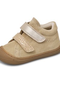 Zapato de ante beige con doble strap de velcro, acentos texturizados, punta redondeada y suela de goma con un patrón de agarre.