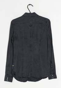 Camicia grigio scuro a maniche lunghe con colletto a button-down, orlo curvo e dettagli di cucitura visibili. Realizzata in tessuto morbido e texture.