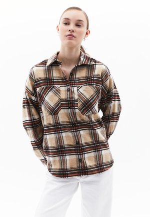 Beige og brun plaid flannel skjorte med sorte og røde detaljer, udstyret med to brystlommer og knaplukning foran. Blød tekstur.