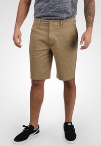 Kaki shorts lavet af bomuld med lige snit, der har en frontlukning med knap, sidelommer og en glat overflade.