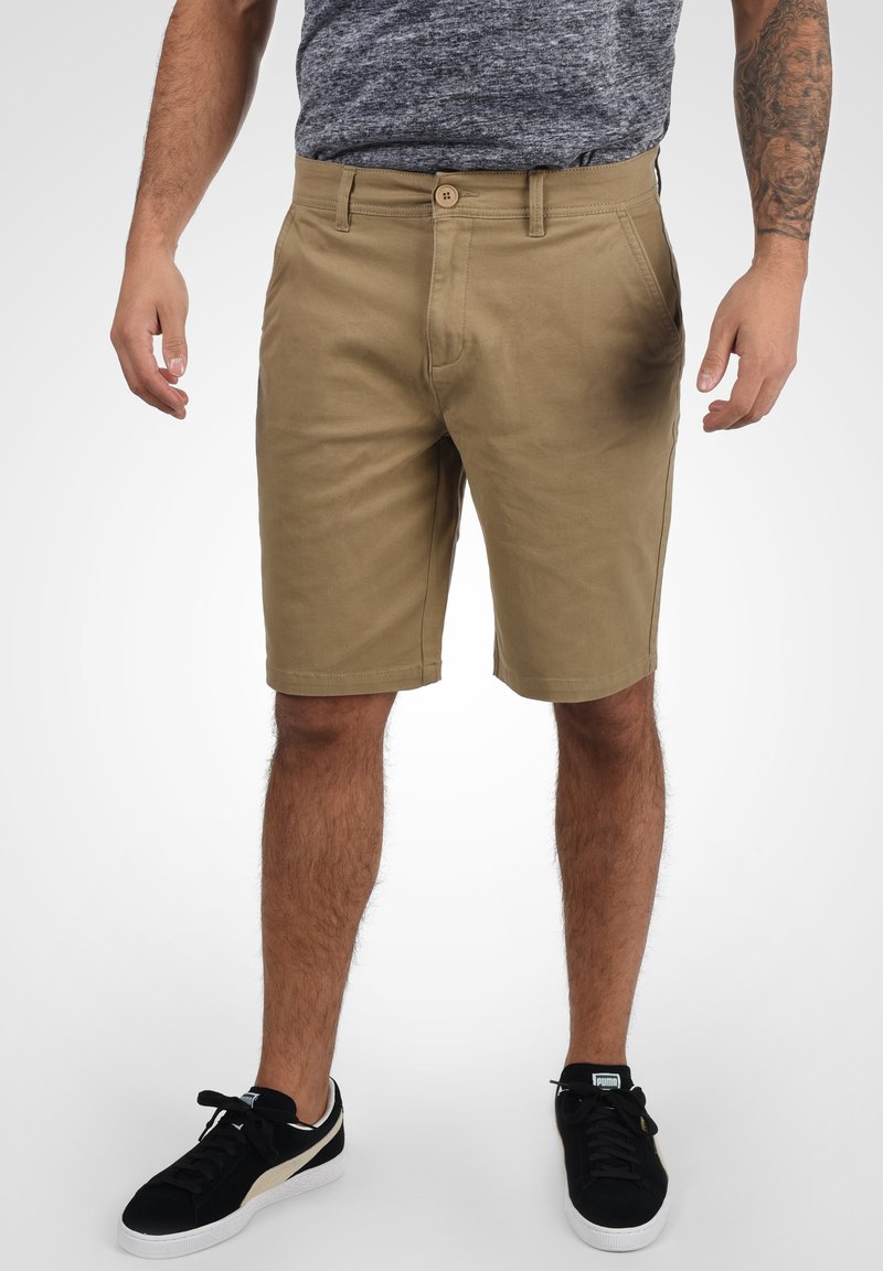 Kaki shorts lavet af bomuld med lige snit, der har en frontlukning med knap, sidelommer og en glat overflade.