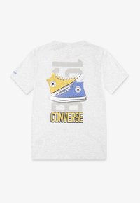 Grå bomullströja med grafik av gula och blå Converse skor, med fet "CONVERSE" text och en ljusgrå bakgrundsdesign.