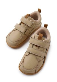 Sneakers in pelle beige con due cinturini in Velcro, punta rotonda, colletto imbottito e suola in gomma. Presentano cuciture in contrasto e dettagli in beige.