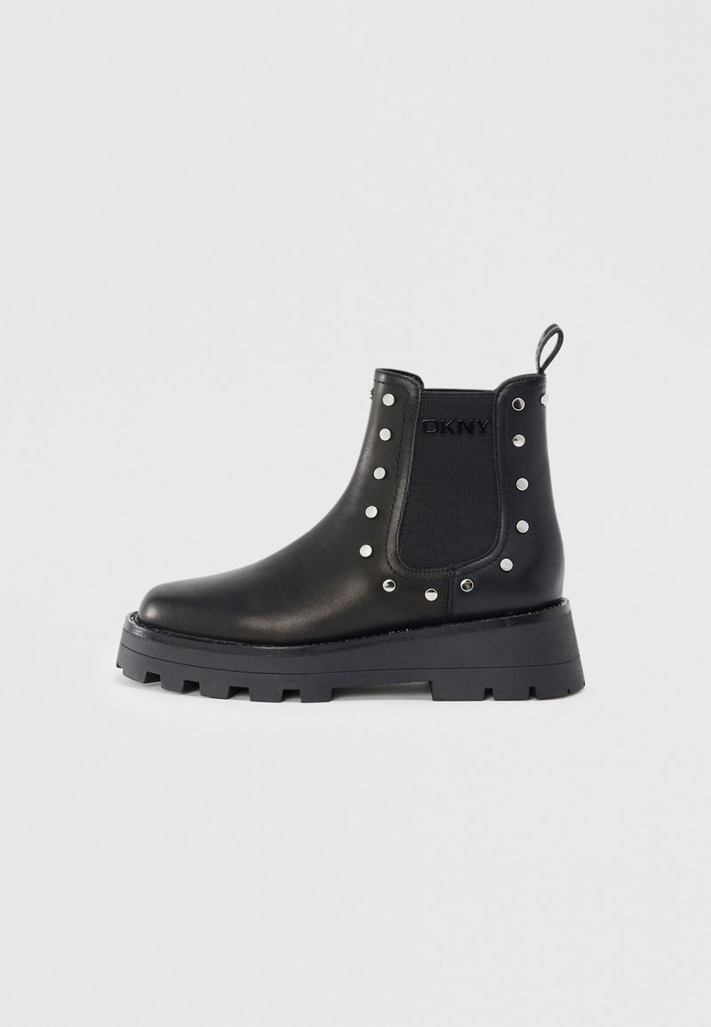 Bottine en cuir noir avec semelle épaisse, clous argentés, panneau latéral élastique, languette de tirage et logo DKNY sur le côté extérieur.
