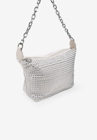 Bolso de mano blanco con una textura suave, adornado con tachuelas plateadas y equipado con una correa de cadena plateada y cierre de cremallera.