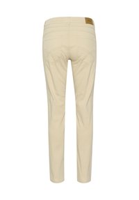 Beige smalle bukser med en glat tekstur, der har baglommer med skrå syninger og et lille læderlogo på linningen.