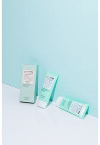 Benton UV Defense Solkräm förpackning och två tuber i mintgröna nyanser, med tryckt text och en slät yta på en vit yta.