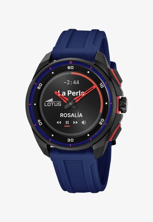 Smartwatch z niebieskim paskiem i czarną, okrągłą tarczą pokazujący odtwarzanie muzyki: „La Perla“ Rosalía, z kontrolkami odtwarzania i logo Lotus.