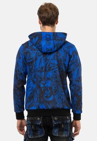 Kapuzensweatshirt aus blauer Baumwolle mit schwarzem Löwen-Graphic-Design, ausgestattet mit gerippten Bündchen und Saum sowie einer Kängurutasche.