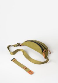 Olijfgroene heuptas met zwarte rits en tan leren accenten. Verstelbare band en platte vorm, ontworpen voor handsfree dragen.