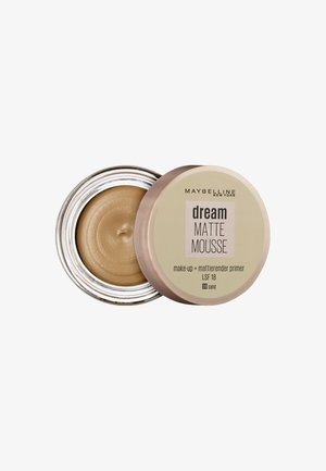 Maybelline Dream Matte Mousse primer i en rund glasbeholder med en sølvkant, der har en lys beige farve og en glat tekstur.
