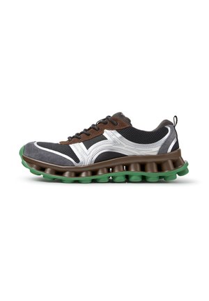 Schwarzer und brauner Sportschuh mit weißen Akzenten, dicker segmentierter brauner Zwischensohle und grüner strukturierter Außensohle.