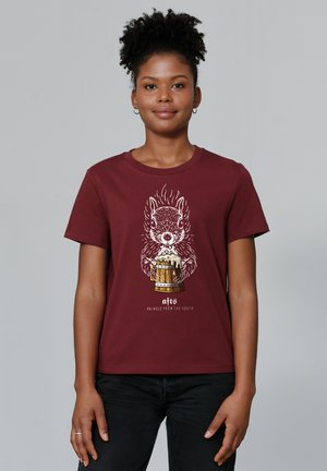 T-shirt en coton bordeaux avec un écureuil en dessin animé tenant une chope de bière, au design fantaisiste avec des accents blancs et dorés. Manches courtes.