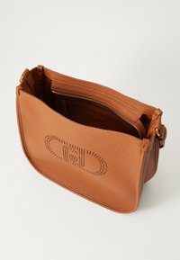 Borsa a spalla in pelle marrone con una finitura testurizzata. Presenta un'apertura superiore e una tasca con zip all'interno. Design decorativo perforato sulla parte anteriore.