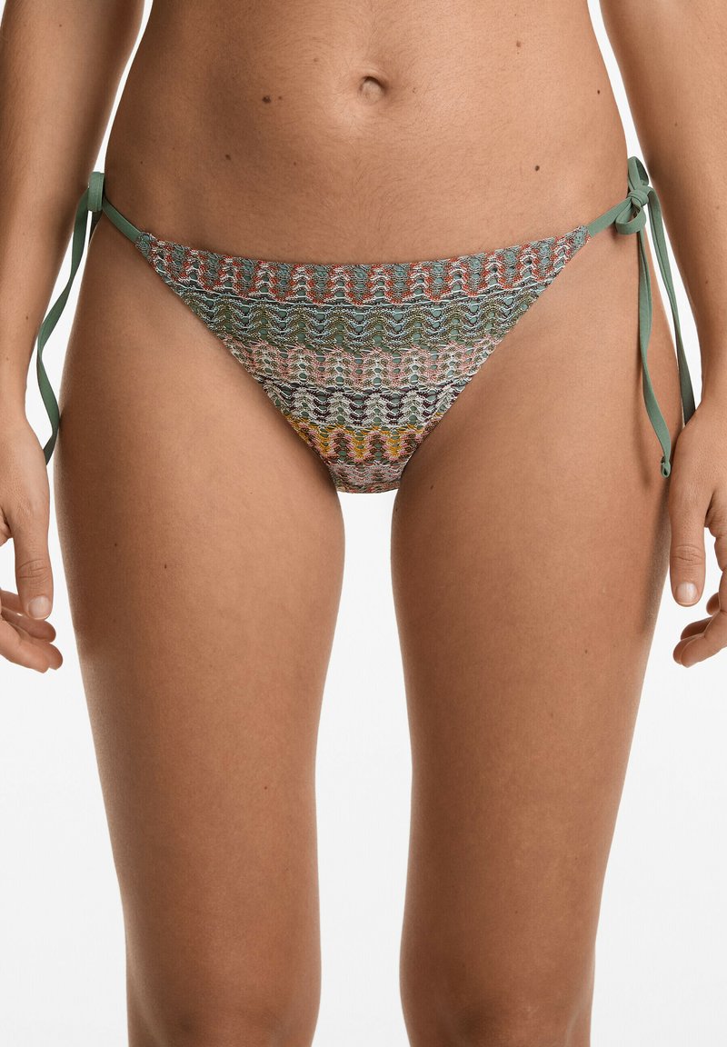 Mintás bikini alsó zöld, narancs és bézs színek keverékével, oldalt megkötős záródással és texturált szövéssel.