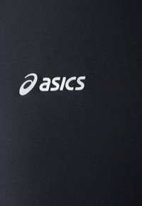 Czarna tkanina sportowa o gładkiej fakturze z wyraźnym białym logo "asics". Prosty, nowoczesny design bez dodatkowych wzorów.