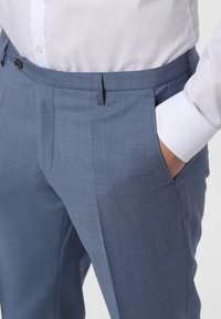 Ljusblå kostymbyxor i texturerad tyg, med rak passform, framfickor och midja med knäppning.