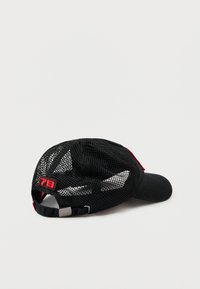 Melna beisbola cepure ar sieta aizmuguri, sarkaniem akcentiem, plakanu vizieri, regulējamu siksniņu un drosmīgu sarkanu "78" aizmugurē. Matēta un teksturēta virsma.