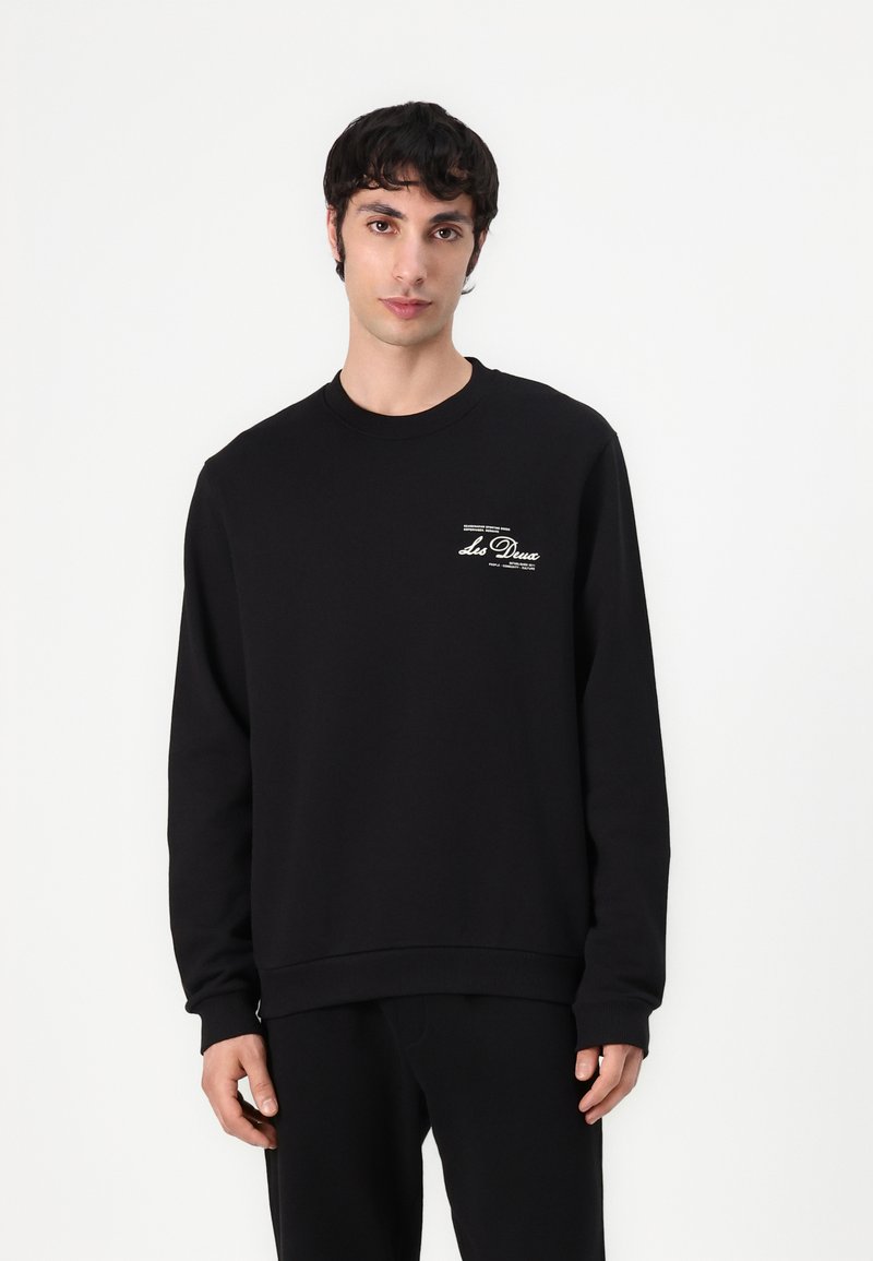 Czarny sweatshirt z miękkiego bawełnianego materiału, z długimi rękawami, okrągłym dekoltem i białym nadrukiem graficznym na lewej piersi.