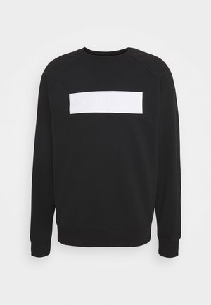 Svart sweatshirt med långa ärmar, ribbade muddar och fåll. Har en vit rektangulär logotypmärke över bröstet. Tillverkad av bomullsblandat tyg.