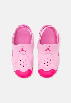 Ροζ σανδάλια slip-on με ρυθμιζόμενα λουριά, οπές αερισμού και ανάγλυφο λογότυπο στην κορυφή, εμφανιζόμενα από πάνω σε λευκό φόντο.