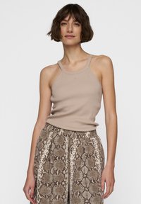 Beige geribbelde tanktop met dunne bandjes, gecombineerd met brede broek met slangenpatroon in bruin en crème met een elastische tailleband.
