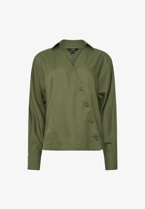 Blusa envolvente verde oliva con mangas largas, escote en V y detalles de botones en el lado. Textura suave, corte relajado y tejido ligero.